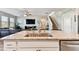 Open-concept kitchen island featuring granite countertops, stainless steel sink, and view of the living area and staircase at 10741 Charlotte Dr, Parrish, FL 34219