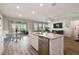 Spacious kitchen with granite island, stainless steel dishwasher, breakfast nook, and a view of the screened-in patio at 10741 Charlotte Dr, Parrish, FL 34219