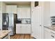 Bright kitchen featuring white cabinets, granite countertops, stainless steel appliances and wood-look flooring at 10741 Charlotte Dr, Parrish, FL 34219