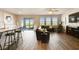 Spacious living room with wood floors, kitchen with island, and access to the outdoor patio through sliding doors at 10741 Charlotte Dr, Parrish, FL 34219