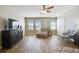 Airy living room featuring wood-style floors, bright windows, and versatile furniture placement at 10741 Charlotte Dr, Parrish, FL 34219