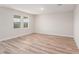 Bright, empty bedroom with light wood flooring and two windows at 12160 Cattleside Dr, Riverview, FL 33579