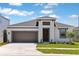 Charming single-story home with a two-car garage, landscaped lawn, and modern architectural details at 12160 Cattleside Dr, Riverview, FL 33579