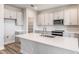 Well-lit kitchen with sleek gray cabinets, quartz countertops, stainless steel appliances, and an island at 12160 Cattleside Dr, Riverview, FL 33579