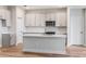 Modern kitchen featuring white cabinets, stainless steel appliances, quartz countertops, and a center island at 12160 Cattleside Dr, Riverview, FL 33579