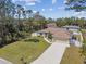 Aerial view of a charming home with a well-manicured lawn, lush landscaping, and inviting curb appeal at 1221 Dustin Rd, North Port, FL 34288