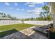 Secluded backyard featuring a paved patio, lawn, and lounge chairs under a sunny sky at 1221 Dustin Rd, North Port, FL 34288