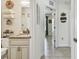 Spacious bathroom featuring a granite-topped vanity, toilet, decorative items and hallway access at 1221 Dustin Rd, North Port, FL 34288