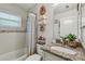 Bathroom with a granite-topped vanity, towel rack and tub and shower with decorative mosaic tile at 1221 Dustin Rd, North Port, FL 34288