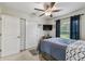 Relaxing bedroom with a ceiling fan, a mounted TV, and a cozy bed with bright white and blue patterned comforter at 1221 Dustin Rd, North Port, FL 34288