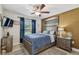 Cozy bedroom featuring a ceiling fan, stylish decor, and a comfortable bed with blue patterned comforter at 1221 Dustin Rd, North Port, FL 34288