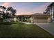 Charming single-story home with a well-manicured lawn, inviting entrance, and two-car garage at 1221 Dustin Rd, North Port, FL 34288