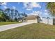 Well-maintained single-story home featuring a manicured lawn, long driveway, and two-car garage at 1221 Dustin Rd, North Port, FL 34288