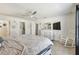 Bright main bedroom boasts a ceiling fan, ensuite bath access, a dresser, and walk-in closet at 1221 Dustin Rd, North Port, FL 34288