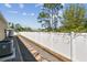 View of the side yard with a gravel pathway, air conditioning unit, and white privacy fence at 1221 Dustin Rd, North Port, FL 34288