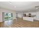 Open living room featuring sleek wood floors and sliding glass doors to the backyard at 14761 Summer Branch Dr, Lithia, FL 33547