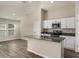 Modern kitchen with stainless steel appliances, dark countertops, white cabinets, and an island with a sink at 14777 Summer Branch Dr, Lithia, FL 33547
