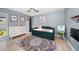 Bright bedroom features a colorful rug, daybed, and white dresser at 1552 Glen Hollow N Ln, Dunedin, FL 34698