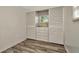 Bedroom featuring wood-look flooring, a window with blinds, and a closet with built-in drawers at 1608 Thrush Dr, Zephyrhills, FL 33540