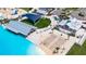 Aerial view showcasing the pool area with a beach section, chairs, shade structures, and an outdoor bar area for residents at 16817 Whisper Elm St, Wimauma, FL 33598