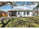 View of a spacious lawn, trees, and back of the house with an enclosed screened patio at 18122 Antietam Ct, Tampa, FL 33647