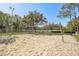 Scenic sand volleyball court with a clear net and surrounded by lush greenery, offering a perfect recreational space at 18122 Antietam Ct, Tampa, FL 33647