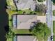 Aerial view of a home with a screened pool and lake access, nestled in a tranquil neighborhood setting at 19826 Wyndham Lakes Dr, Odessa, FL 33556