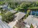 Aerial view showcasing a neighborhood and lake with nearby homes featuring screened pools at 19826 Wyndham Lakes Dr, Odessa, FL 33556