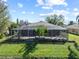 Aerial view of a home with a screened pool, lush landscaping, and a well-maintained lawn at 19826 Wyndham Lakes Dr, Odessa, FL 33556
