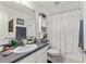 Functional bathroom with a vanity, mirror, and shower featuring a decorative white curtain at 19826 Wyndham Lakes Dr, Odessa, FL 33556