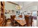 Spacious dining room with wooden table and chairs, accented by a vintage chandelier and Gathering picture display at 19826 Wyndham Lakes Dr, Odessa, FL 33556