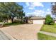 Charming single-story home featuring a brick-paved driveway and a well-manicured lawn at 19826 Wyndham Lakes Dr, Odessa, FL 33556