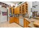 Charming kitchen featuring bright wood cabinets, a white dishwasher, and ample countertop space, complete with cheerful decorations at 19826 Wyndham Lakes Dr, Odessa, FL 33556