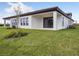 Spacious backyard features lush green grass and modern exterior design at 1988 Webbstone Way, Zephyrhills, FL 33541