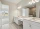 Bright bathroom with double sinks, quartz countertops and a large mirror at 1988 Webbstone Way, Zephyrhills, FL 33541