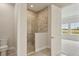 Bright bathroom features tiled shower and view into adjacent bedroom at 1988 Webbstone Way, Zephyrhills, FL 33541