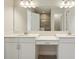 Well-lit bathroom features double sinks, white cabinetry, quartz counters, and a large mirror at 1988 Webbstone Way, Zephyrhills, FL 33541