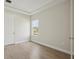 Cozy bedroom featuring tray ceiling, neutral walls, light hardwood floors, and ample natural light at 1988 Webbstone Way, Zephyrhills, FL 33541