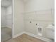 Spacious laundry room with sink, overhead rack, and washer and dryer hookups at 1988 Webbstone Way, Zephyrhills, FL 33541
