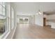Spacious living room with wood floors, large windows, and sliding glass doors offering views of the surrounding landscape at 1988 Webbstone Way, Zephyrhills, FL 33541
