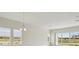 Spacious living room with ample natural light from large windows and sliding doors, featuring a modern chandelier at 1988 Webbstone Way, Zephyrhills, FL 33541