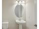 Powder room features pedestal sink with oval mirror and white toilet at 1988 Webbstone Way, Zephyrhills, FL 33541