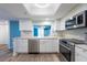 Bright kitchen with white cabinets, stainless steel appliances, and a light-filled breakfast bar overlooking the dining area at 201 W Laurel St # 811, Tampa, FL 33602