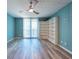 Bright living room with sliding glass doors, wood-look floors, and built-in shelves at 201 W Laurel St # 811, Tampa, FL 33602
