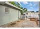 Exterior view of the backyard featuring a concrete patio, partial fencing, and a well-kept exterior wall at 2017 Princeton Ave, Dunedin, FL 34698