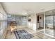 Bright sunroom with tiled floors, a ceiling fan, large windows and a sliding glass door to dining area at 2017 Princeton Ave, Dunedin, FL 34698