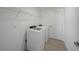 Bright laundry room featuring a modern washer and dryer set with tiled flooring and wire shelving at 20308 Silent Ave, Port Charlotte, FL 33981