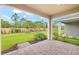 Spacious covered patio with brick pavers overlooks a large yard with privacy landscaping at 20387 Symphony Pl, Venice, FL 34293