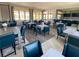 The dining area features many tables with seating for residents, with many windows and light providing natural light at 20387 Symphony Pl, Venice, FL 34293