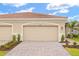 Attached two-car garage with decorative driveway and landscaping provides attractive curb appeal at 20387 Symphony Pl, Venice, FL 34293